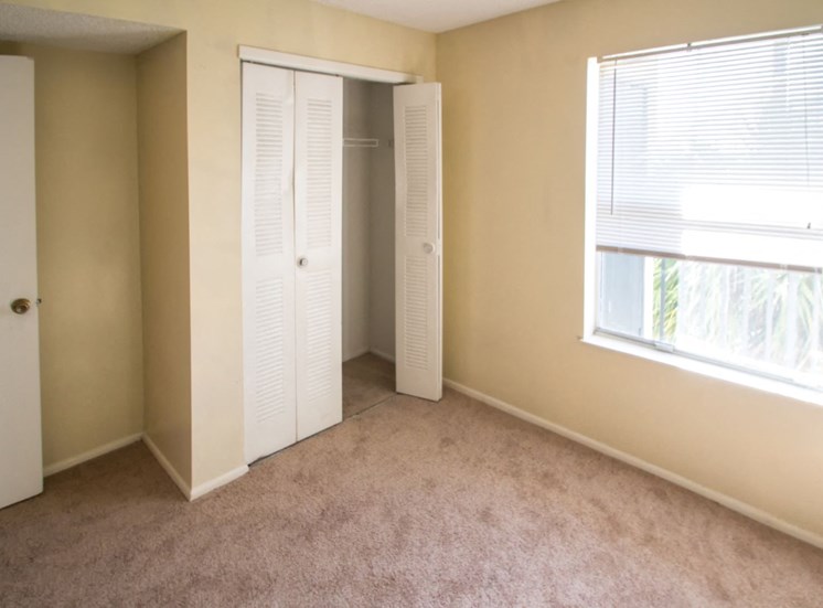 Bedroom with Carpet Flooring, white double closet doors and large window